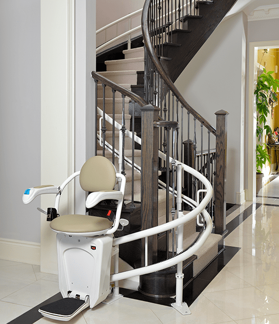 Stairs Ramp Seating A Residential Curved Stair Lift with a padded seat and armrests is ...