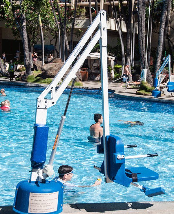 A pool lift chair is positioned at the edge of an outdoor swimming pool ...