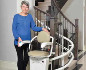 Lady Standing by Stairs with a Curved Stairlift in Galena, Naperville, Glenview, Hinsdale, Springfield, Kankakee