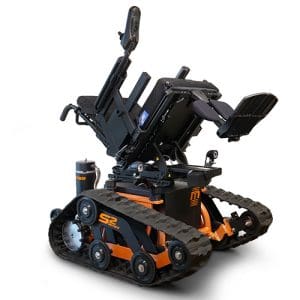 A rugged, black and orange motorized wheelchair with tank-like treads and a reclining seat, designed for all-terrain mobility and accessibility for users with disabilities.