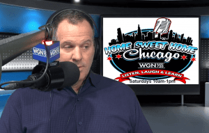 A radio host speaks into a microphone labeled “WGN Radio” in a studio. Behind him is a screen displaying the “Home Sweet Home Chicago” show logo with details for WGN 720, airing Saturdays 10am–1pm.