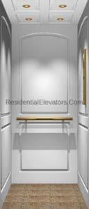 A residential elevator interior with white paneled walls, a wooden handrail, recessed ceiling lights, and a padded beige floor. A small window is on the right wall.