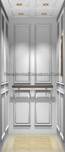 Interior view of a residential elevator with white paneled walls, a wooden handrail, recessed ceiling lights, and a light-colored floor.