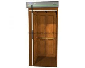 A wooden residential elevator with double doors open, showing a simple interior and an overhead panel.