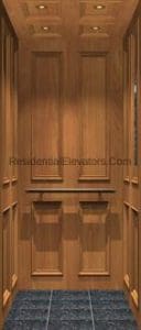 Interior of a residential elevator with wood-paneled walls, recessed lighting in the ceiling, and a dark textured floor. The design appears classic and elegant.