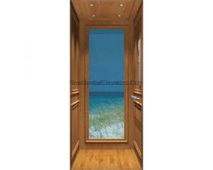 A wood-paneled elevator interior with a large window showing an underwater ocean view, including blue water and a sandy sea floor.