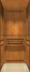 Wood-paneled elevator interior with recessed lighting on the ceiling and a light-colored tile floor; decorative molding lines the walls.