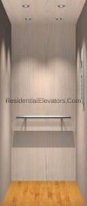 A small, modern residential elevator with light wood walls, a wooden floor, three ceiling lights, a safety handrail on the back wall, and a control panel on the right wall.