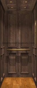 A small elevator interior with dark wooden wall panels, a wooden handrail, recessed ceiling lights, and a light brown wood floor.