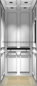 A modern residential elevator interior with white paneled walls, recessed ceiling lights, a horizontal handrail, and a light-colored floor.