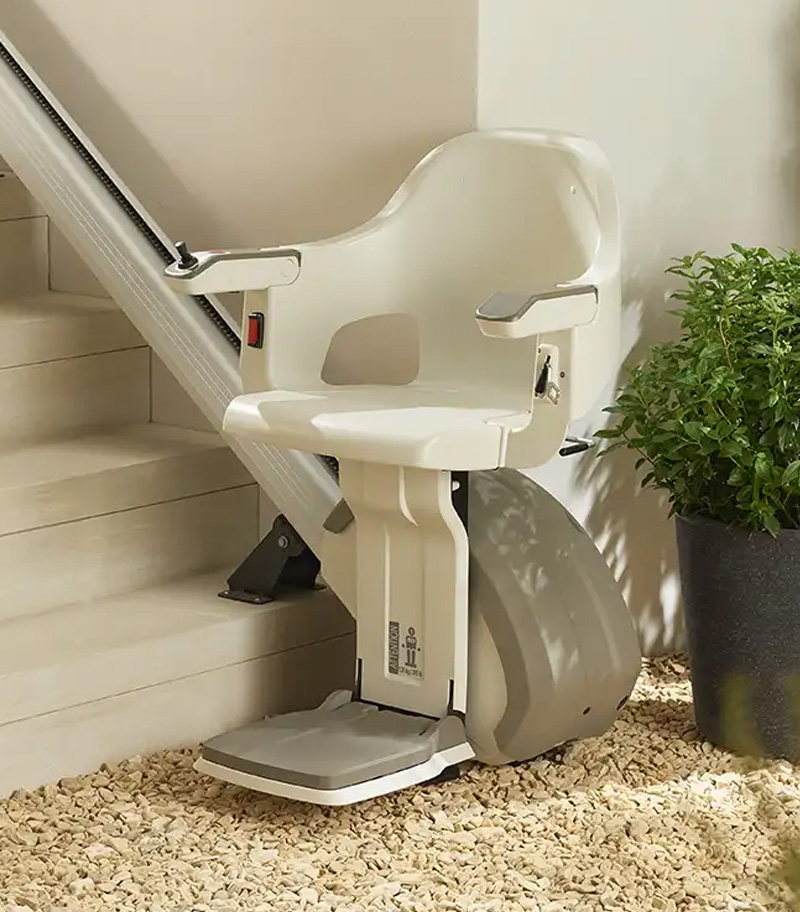 Access BDD HomeGlide Outdoor Straight Stair Lift with Plant in Background Mounted to Concrete Steps