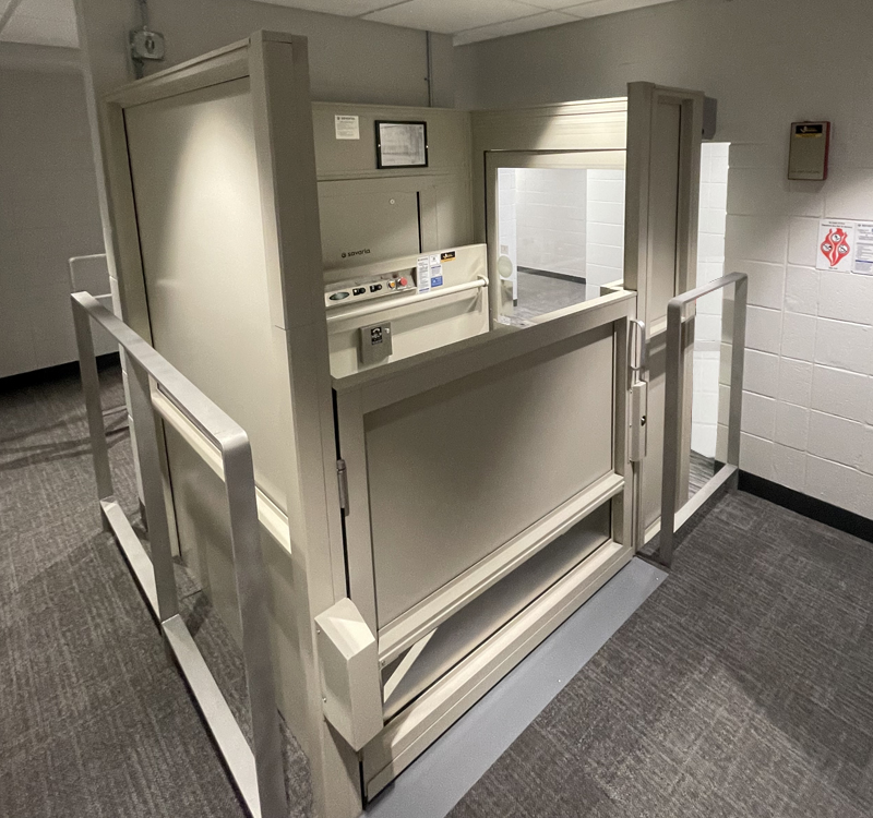 Commercial building entrance featuring an ADA-compliant ramp and vertical platform lift installed by Access Elevator, Inc.