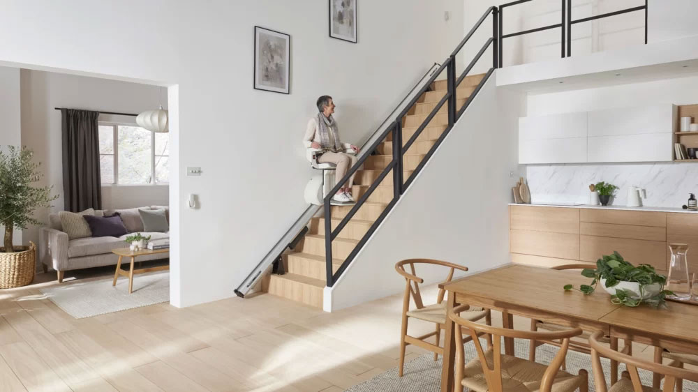 Access BDD Straight Stair Lift Halfway Up the Stairs with Rider Looking Up