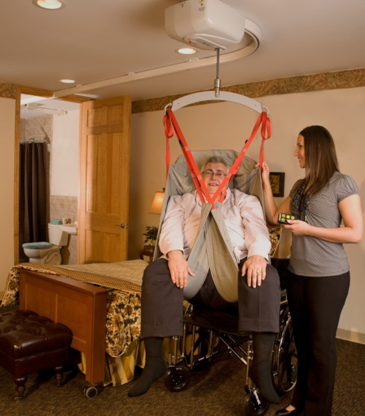 Caregiver using SureHands Bariatric Ceiling Lift to easily and safely assist in patient transfers