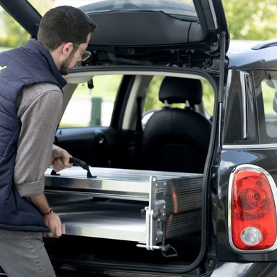 Portable wheelchair ramp from National Ramps being loaded into car's trunk