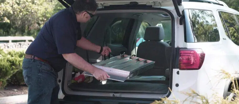 Bi-Fold Portable Wheelchair Ramp from National Ramps being stowed in car.
