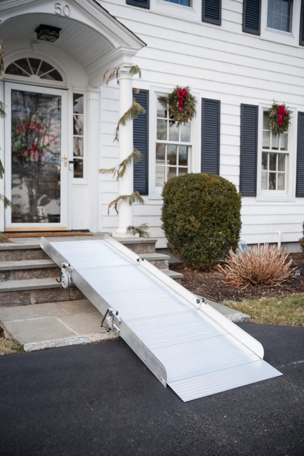 Aluminum Portable Ramp from National Ramps with 800 lbs weight capacity up to 12" rise. Ramp is shown spanning three steps.