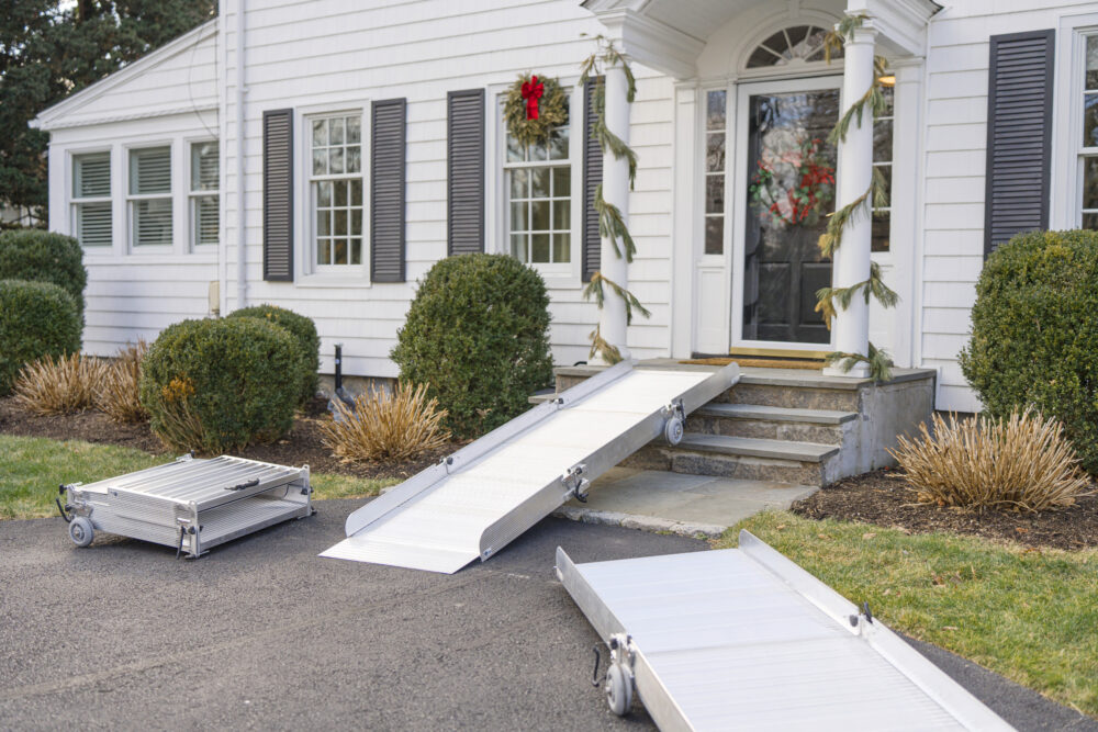 Portable wheelchair ramp from National Ramps shown at door, flat on ground, and folded for easy transport and storage