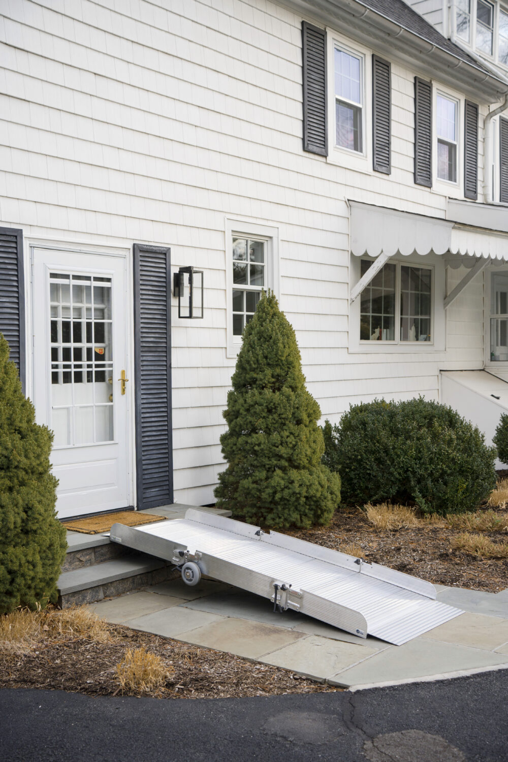 Tri-fold aluminum portable wheelchair ramp from National Ramps. Ramp is placed at door, allowing easy access to home