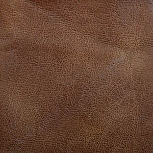 Close-up of brown leather texture with natural creases and fine grain patterns, as seen on the Titan with Twilight Medium - Lift Chair by Golden Technologies.