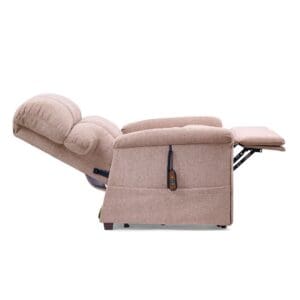 The Comforter Large - Lift Chair by Golden Technologies in beige is fully reclined with its plush cushioning and extended footrest. A remote control on the side highlights its power-adjustable, oversized comfort design.