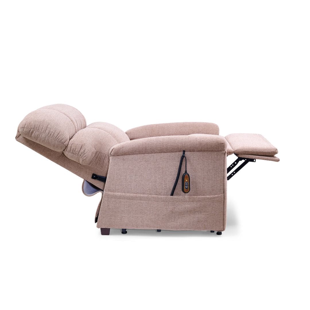 A Comforter Medium Wide - Lift Chair by Golden Technologies in beige is fully reclined with its footrest elevated and a remote control hanging from the side. The background is plain white. A Comforter Medium Wide - Lift Chair by Golden Technologies in beige is fully reclined with its footrest elevated and a remote control hanging from the side. The background is plain white.
