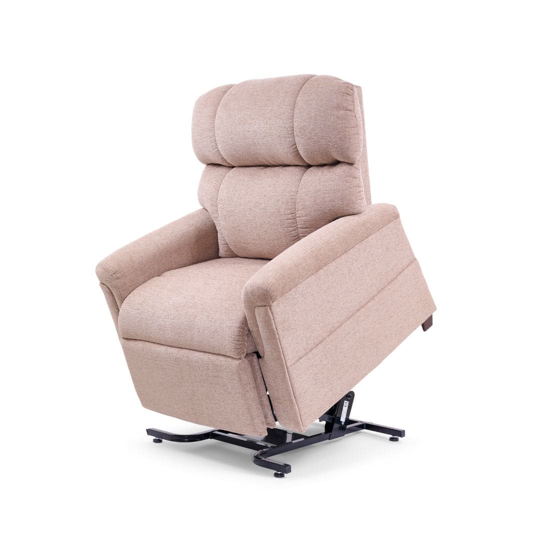 The Comforter Small Wide - Lift Chair by Golden Technologies features beige upholstery, cushioned back and armrests, and is shown partially raised on a black metal lift mechanism against a white background. The Comforter Small Wide - Lift Chair by Golden Technologies features beige upholstery, cushioned back and armrests, and is shown partially raised on a black metal lift mechanism against a white background.