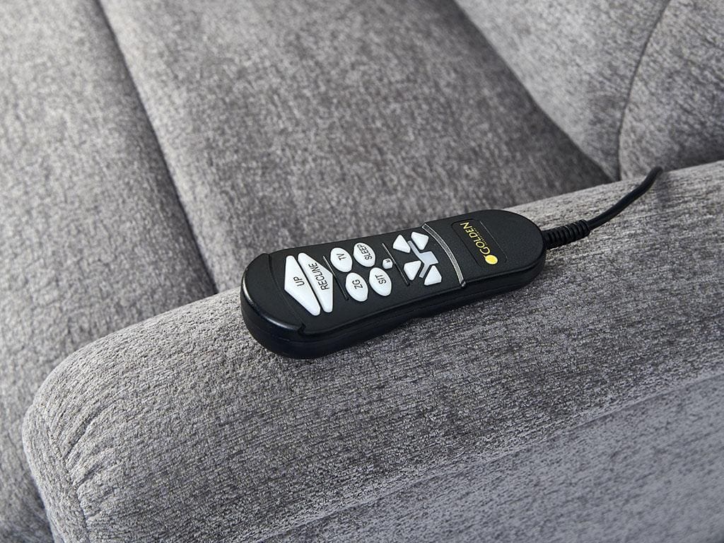 A black remote with white buttons, labeled Up, Preset, and arrows, rests on the arm of a gray Comforter with MaxiComfort Tall Lift Chair by Golden Technologies. The remote is wired to the lift chair.