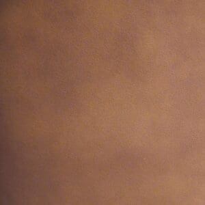 Close-up of a brown, textured surface resembling leather or suede, similar to the upholstery on the Rhea Medium - Lift Chair by Golden Technologies, featuring a soft, slightly uneven color pattern.