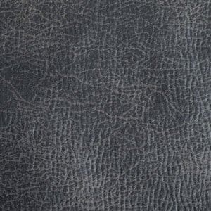 Close-up of a dark gray, leather-like textured surface similar to the premium upholstery on the Titan Medium - Lift Chair by Golden Technologies, featuring irregular raised lines and creases that form a natural, organic pattern.