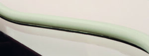 A close-up of the curved, padded armrest with a light green top and black underside from the Freecurve Curved Stair Lift by Handicare, shown against a light background.