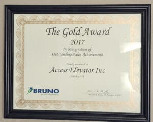 A framed certificate titled The Gold Award 2017 is presented to Access Elevator Inc. for outstanding sales achievement, signed by Michael R. Bruno II, President & CEO, with the BRUNO company logo at the bottom left.