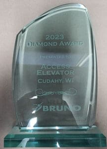 A glass award engraved with 2023 Diamond Award Presented to Access Elevator Cudahy, WI above the Bruno company logo, displayed against a plain background.