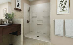 Modern bathroom with beige walls, a walk-in shower with built-in shelves and a grab bar, a dark wood vanity, potted plant, two white towels on a rack, and framed artwork on the walls.