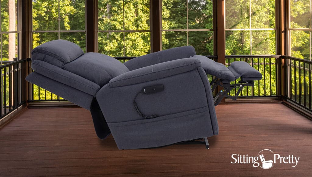 An Evolution (LC-435) Lift Chair by Pride Mobility in dark gray is placed on an enclosed porch with large windows overlooking green trees. "Sitting Pretty" and a chair logo appear at the bottom right.