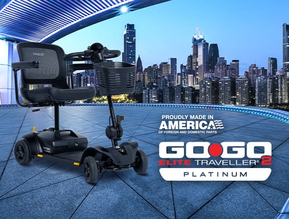 A black Go Go Elite Traveller 2 Platinum 3-Wheel Scooter by Pride Mobility is displayed on a modern terrace with a city skyline. The image highlights that it’s proudly made in America alongside the product name and logo.