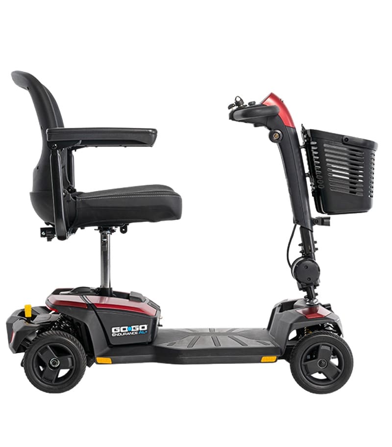 The Go Go Endurance AL+ 4-Wheel Scooter by Pride Mobility, in black and red, features a padded seat, armrests, and a front basket, pictured from the side against a white background. The Go Go Endurance AL+ 4-Wheel Scooter by Pride Mobility, in black and red, features a padded seat, armrests, and a front basket, pictured from the side against a white background.