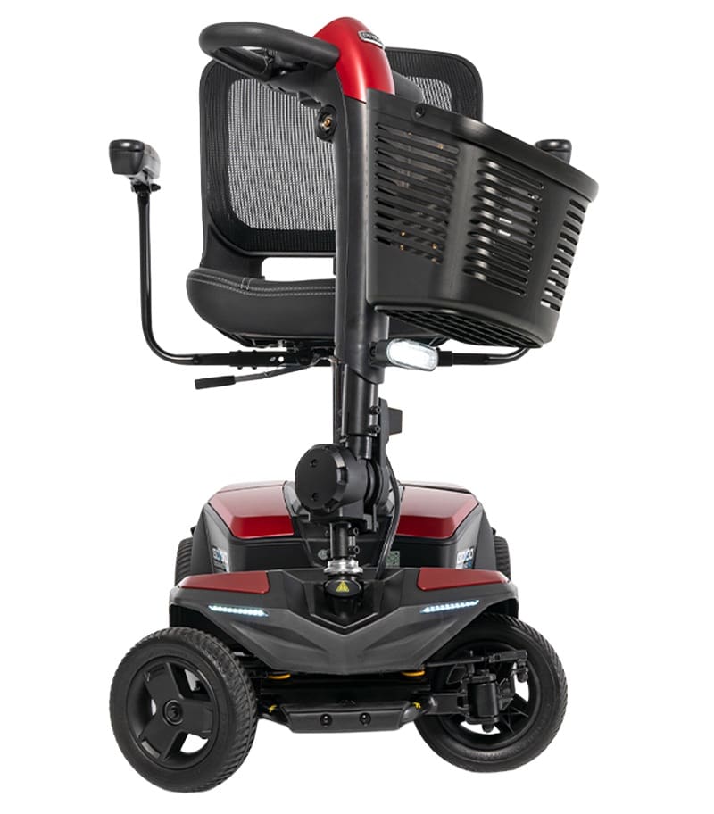 The Go Go Endurance AL+-Wheel Scooter by Pride Mobility is a compact red outdoor mobility scooter with four wheels, a black mesh backrest, large black front basket, and LED headlights, shown from the front view. The Go Go Endurance AL+-Wheel Scooter by Pride Mobility is a compact red outdoor mobility scooter with four wheels, a black mesh backrest, large black front basket, and LED headlights, shown from the front view.
