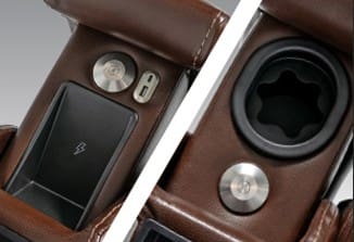 Close-up of the VivaLift Premier PLR-5900 lift chair's brown leather armrest, featuring a wireless charging pad, two metallic buttons, a USB port, and a cup holder with flexible insert by Pride Mobility.