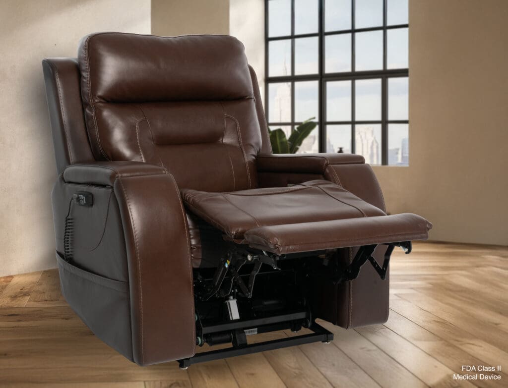 The VivaLift Premier - PLR-5900 Lift Chair by Pride Mobility, featuring brown leather and an extended footrest, is placed on a wooden floor in a sunlit room with large windows and beige walls.