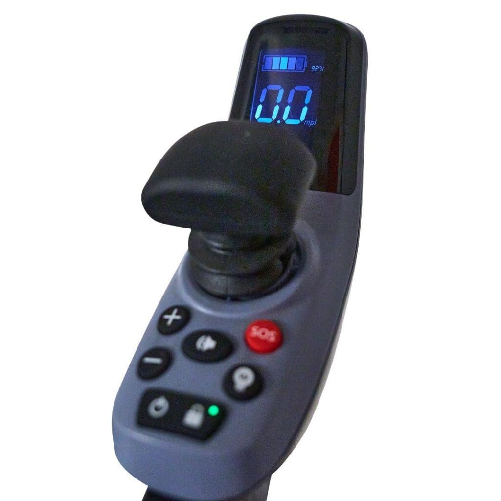 Close-up of the digital joystick controller on the Ally Sport - Power Wheelchair by Golden, featuring a display with 0.0 mph and battery level, plus various buttons including plus, minus, and a red SOS button.