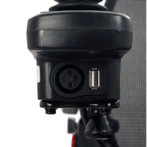 Close-up of a black electronic component on the Cricket - Power Wheelchair by Golden, featuring a three-pin circular connector and USB port, secured with screws to a vertical surface.