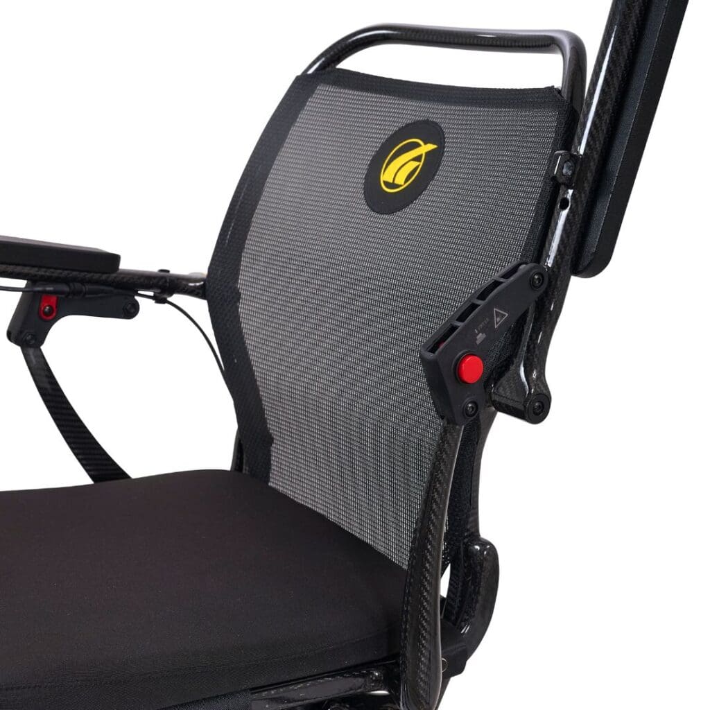 Close-up of the Cricket - Power Wheelchair by Golden, a modern foldable chair with a lightweight metallic frame, black mesh backrest with embroidered yellow logo, adjustable armrest, and visible adjustment buttons for portability.