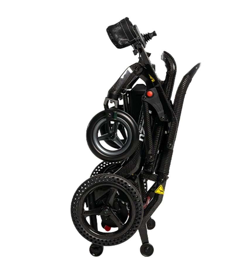 A compact, black Jazzy Ultra Light Power Wheelchair by Pride Mobility is folded for storage, displaying its wheels, footrests, and joystick against a white background. A compact, black Jazzy Ultra Light Power Wheelchair by Pride Mobility is folded for storage, displaying its wheels, footrests, and joystick against a white background.