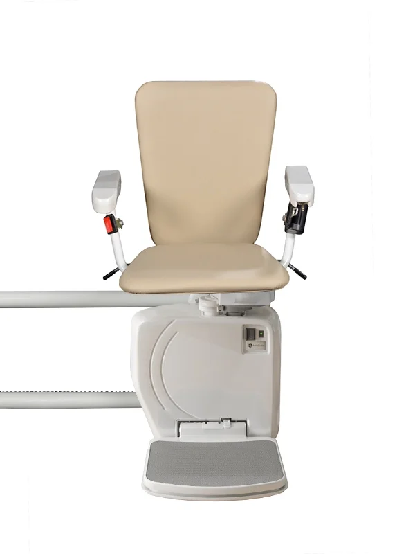 The Stairfriend 23 Curved Stair Lift by Handicare is a beige chair with armrests and footrest, mounted on a rail, designed to help people with mobility challenges go up and down stairs. The background is white.