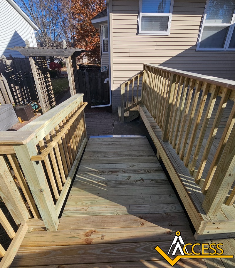 Custom wooden wheelchair ramp installed at a residential home in Colona, Illinois, featuring pressure-treated lumber, safety handrails, and a gradual incline designed to provide safe and reliable accessibility for wheelchair and mobility device users.