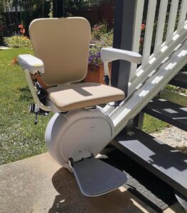 Savaria K2 outdoor stairlift installed on an exterior staircase, featuring a weather-resistant seat, durable rail system, foldable footrest, and protective outdoor construction designed to provide safe and reliable access to porches, decks, and entryways in various weather conditions.