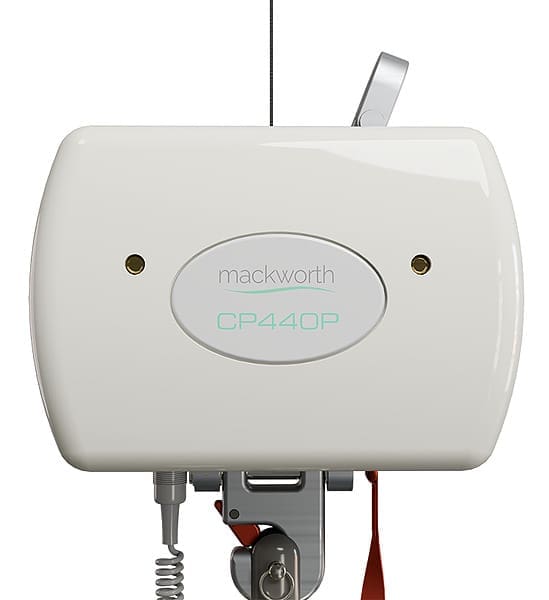 A close-up of a white Portable Ceiling Lift System by Mackworth, featuring a smooth rectangular casing, small sensors or lights, visible lever, coiled cable, and the brand name on the front. A close-up of a white Portable Ceiling Lift System by Mackworth, featuring a smooth rectangular casing, small sensors or lights, visible lever, coiled cable, and the brand name on the front.