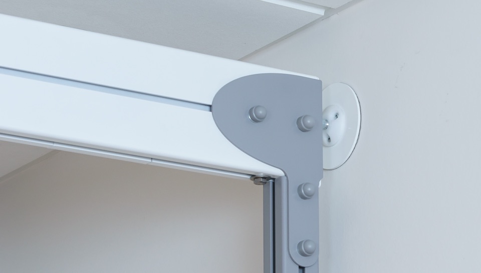 FreedomBridge-SureHands-03 Close-up of a SureHands ceiling lift track corner connection mounted to the ceiling, showing the durable overhead rail system used for safe patient transfers.
