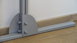 Close-up of a SureHands free-standing ceiling lift support base, showing the sturdy floor-mounted frame designed to provide stable patient transfers without permanent installation.